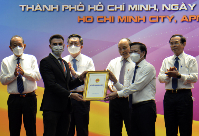 Chủ tịch UBND TP HCM Phan Văn Mãi (phải) trao giấy chứng nhận đầu tư cho một doanh nghiệp tại hội nghị chiều nay. Ảnh: Thu Hằng
